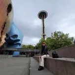 woman sitting on bench under seattle space needle