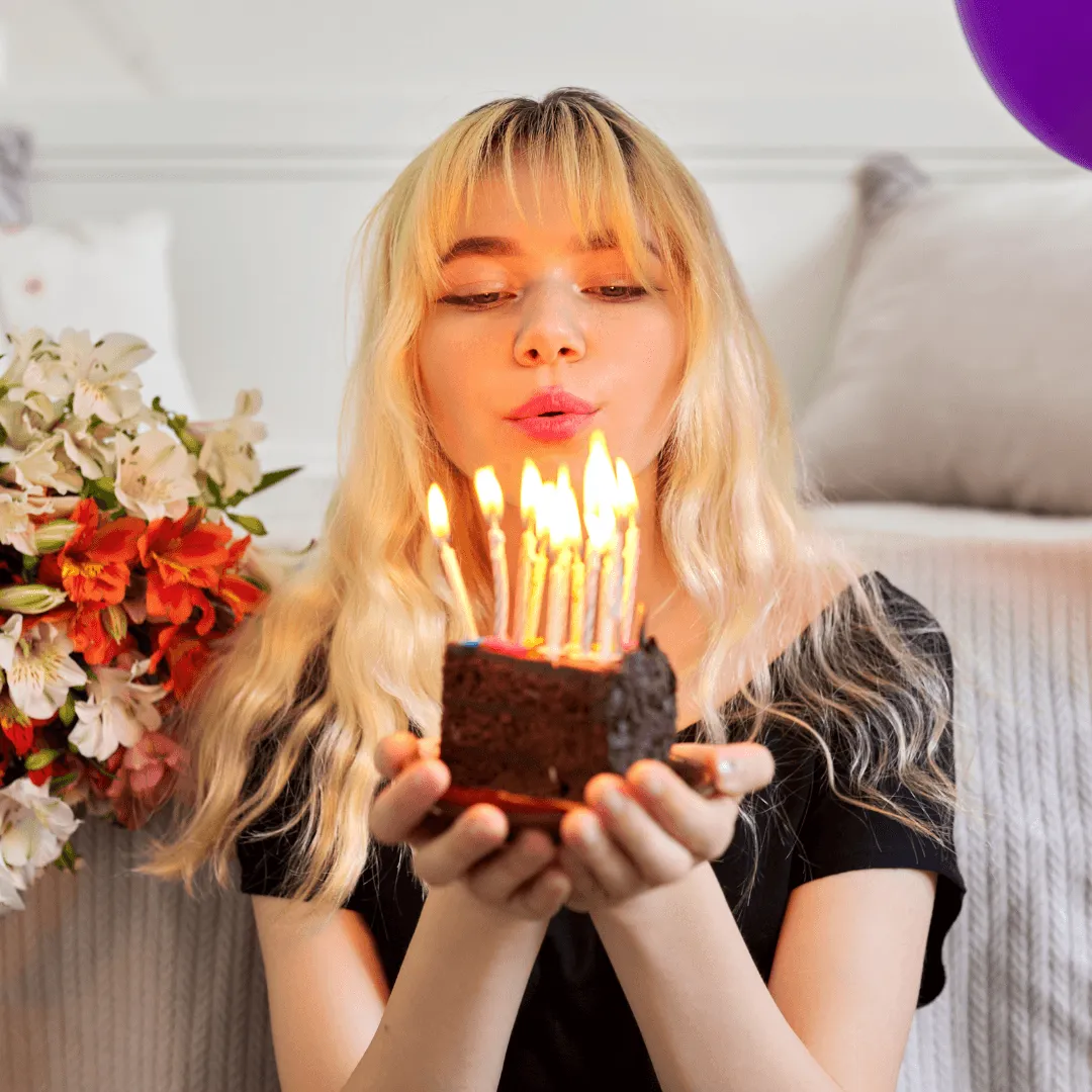 blonde girl blowing out candles on a cake