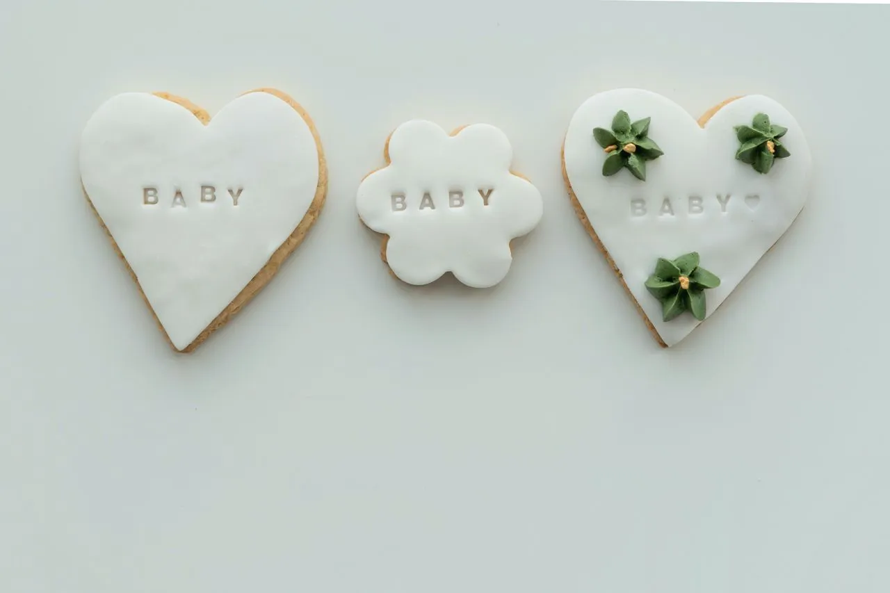 Baby shower cookies with white icing and floral details.