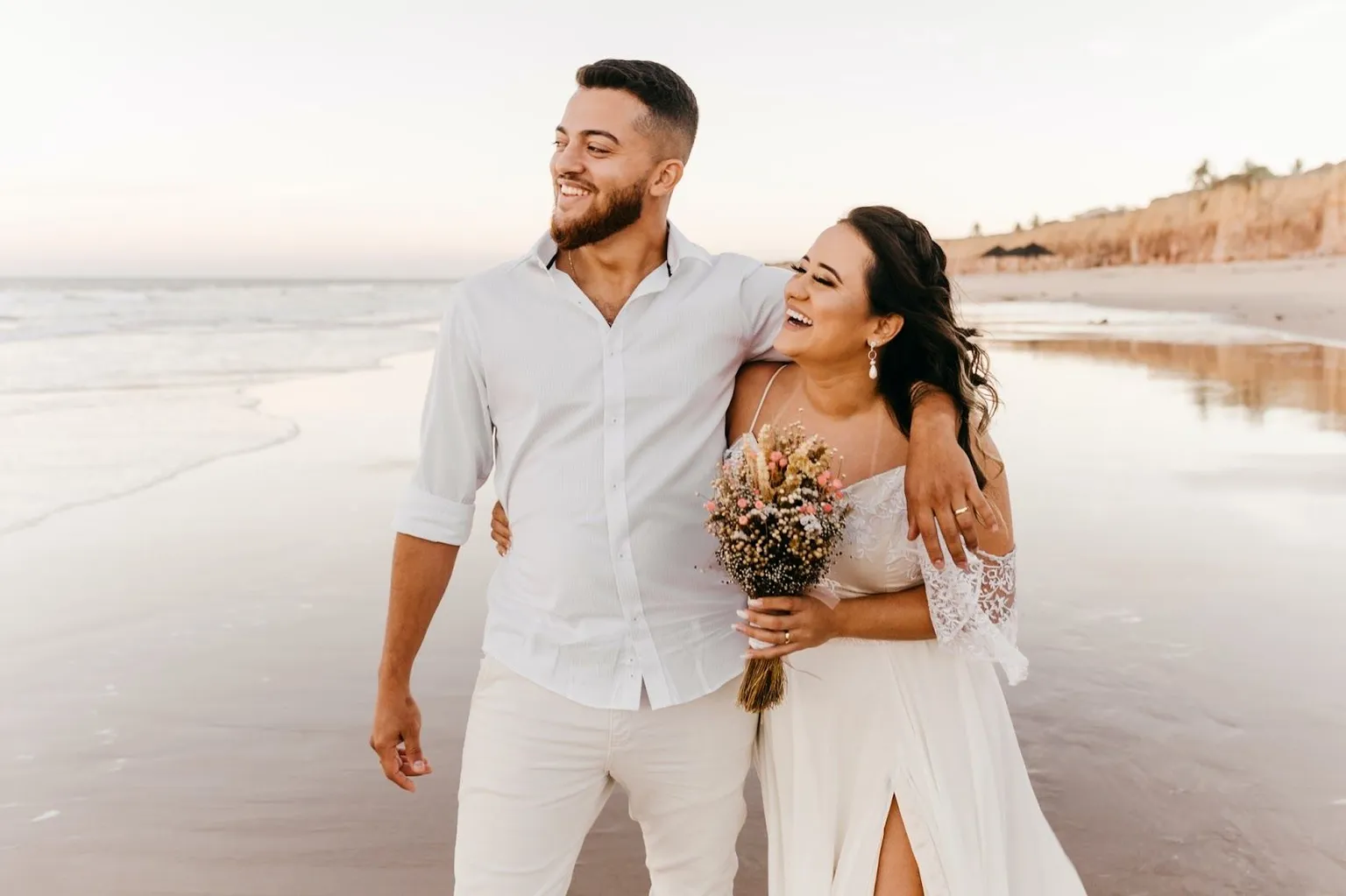 Married couple on the beach taking wedding photos