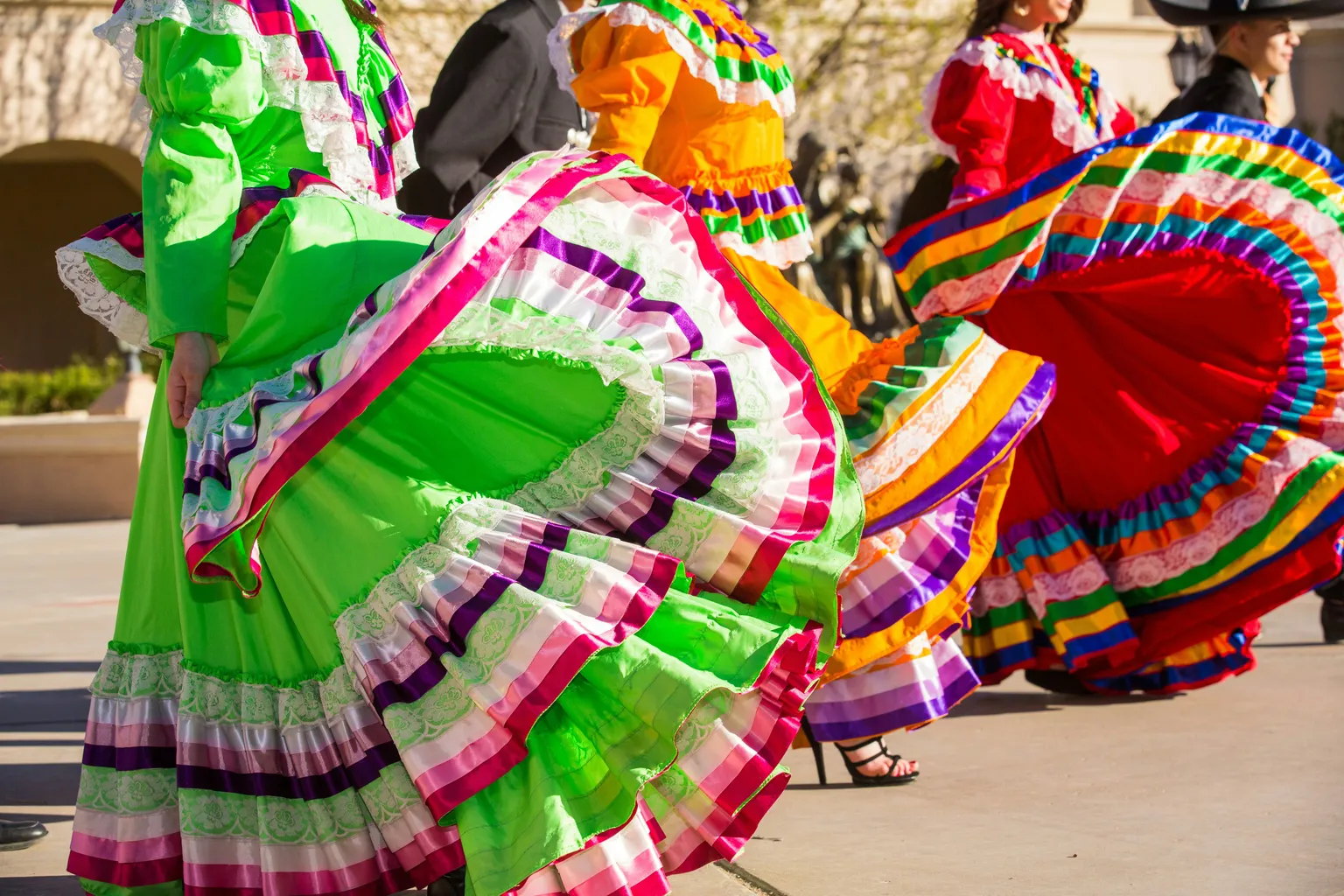 Dancers twirling vibrant traditional dresses in a lively folkloric dance celebration.
