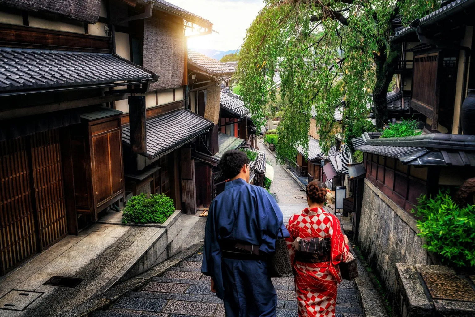 Couple in kimonos walking down a traditional Japanese street.