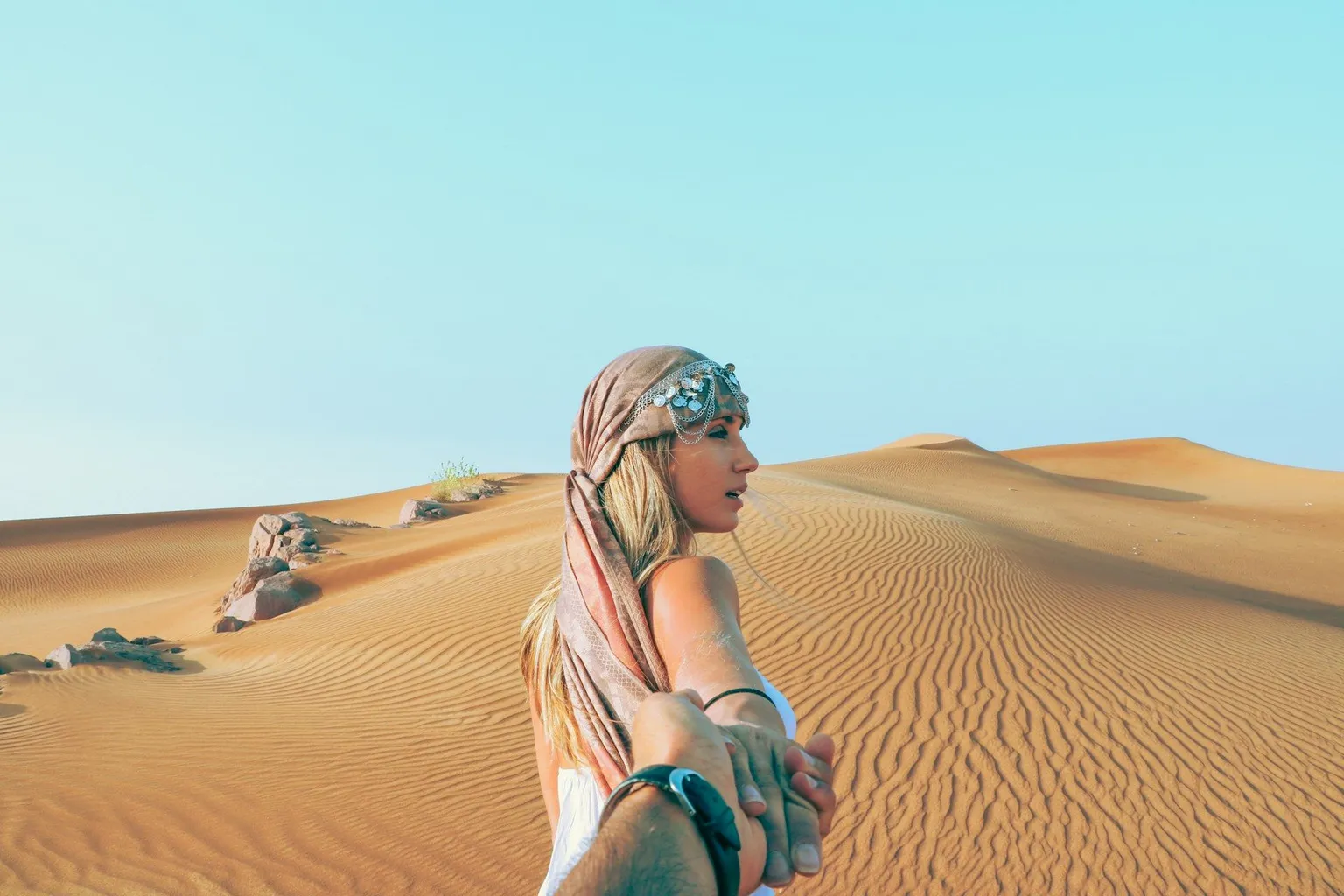 Woman in a headscarf exploring golden sand dunes on a Dubai desert safari.