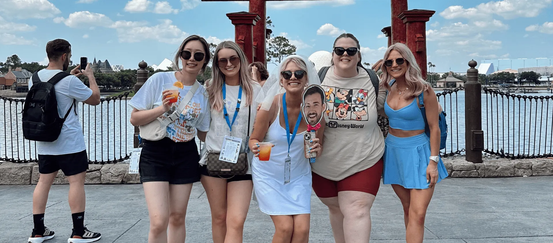group of five women at disneyland wearing sunglasses and smiling at camera