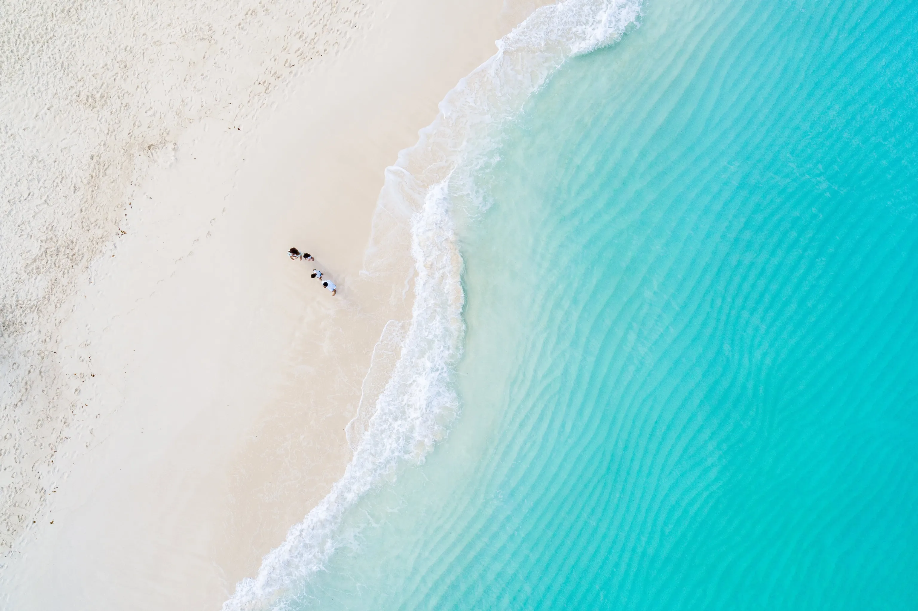 bird's eye view of family walking along ocean shore at Beaches Resorts