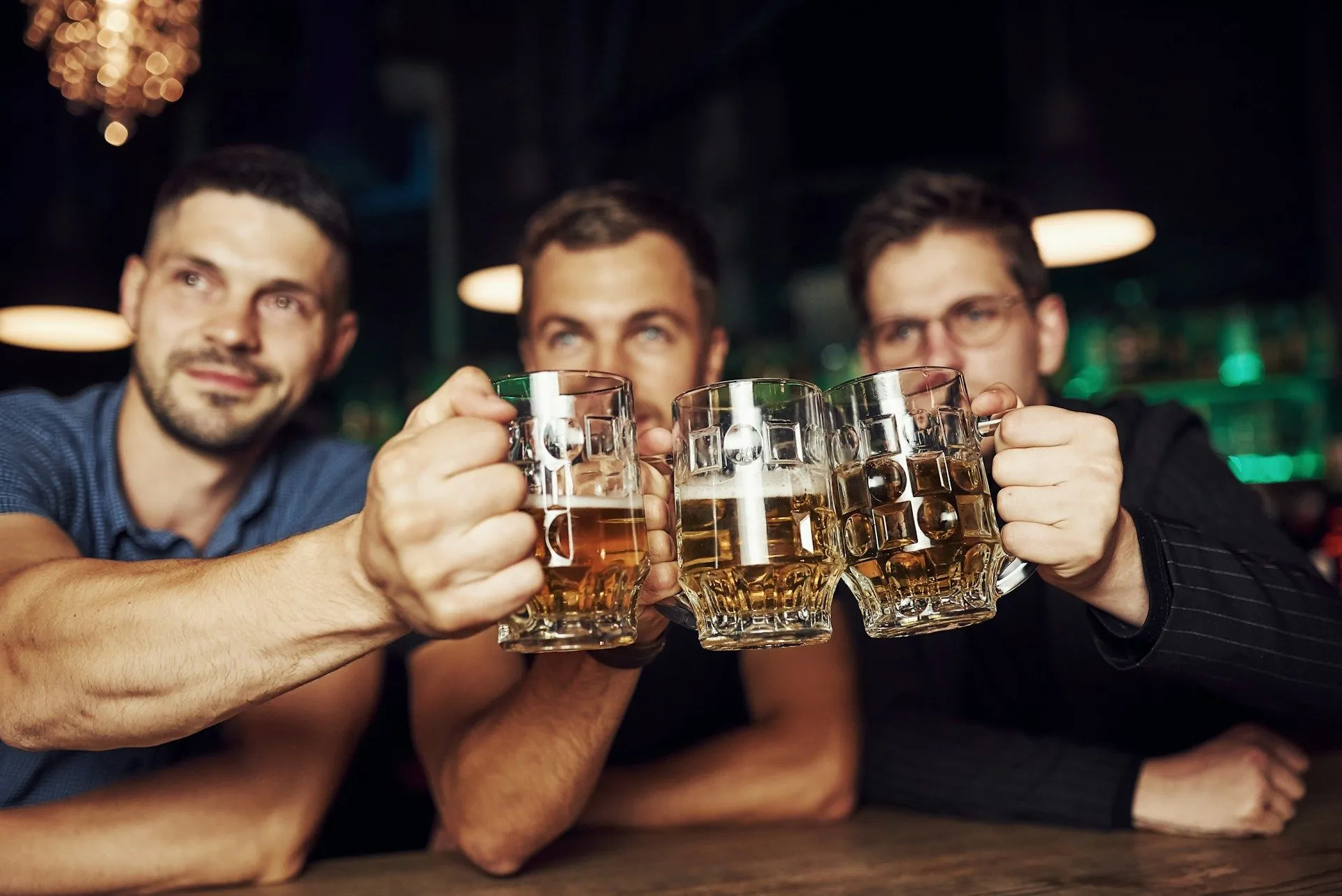People at a bar holding beer