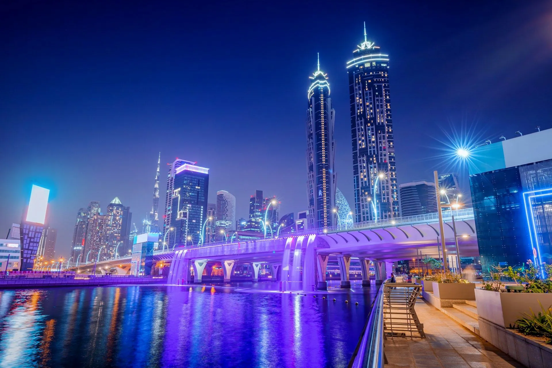 tall building and cityscape at night lit up with blue lights