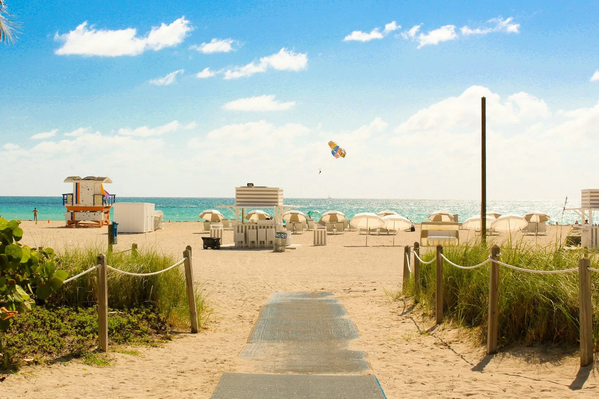 Sunny South Beach in Miami with white sand and oceanfront umbrellas.
