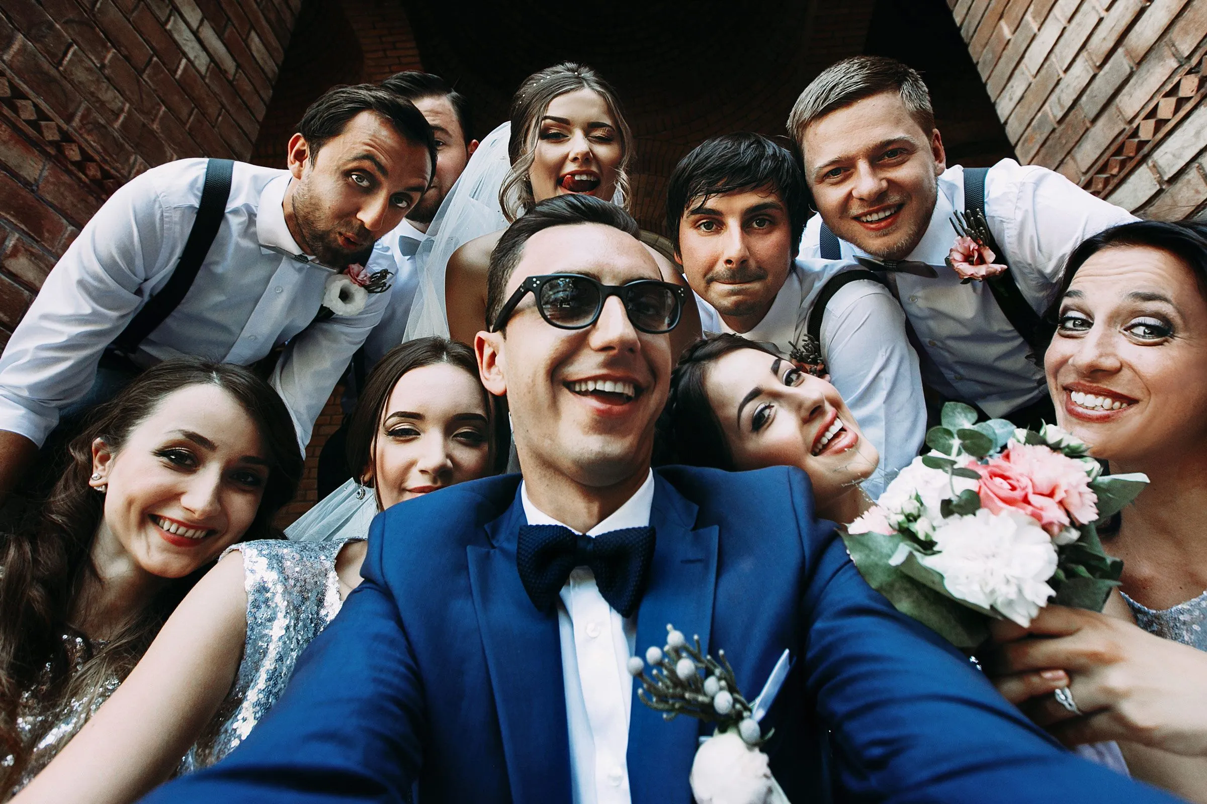 Wedding party taking a fun group selfie with the bride and groom.